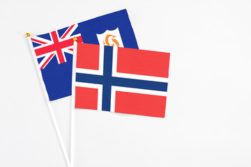 Norway and Anguilla stick flags on white background. High quality fabric, miniature national flag. Peaceful global concept.White floor for copy space.