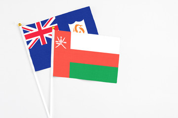 Oman and Anguilla stick flags on white background. High quality fabric, miniature national flag. Peaceful global concept.White floor for copy space.