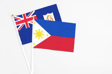 Philippines and Anguilla stick flags on white background. High quality fabric, miniature national flag. Peaceful global concept.White floor for copy space.