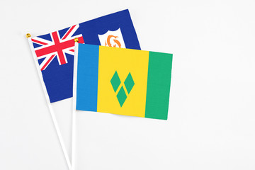 Saint Vincent And The Grenadines and Anguilla stick flags on white background. High quality fabric, miniature national flag. Peaceful global concept.White floor for copy space.