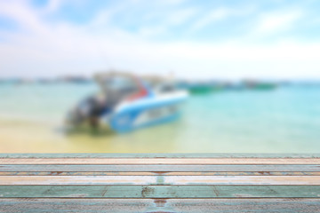 Wood table top with blurred boat at the beach