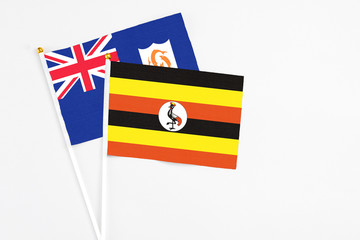 Uganda and Anguilla stick flags on white background. High quality fabric, miniature national flag. Peaceful global concept.White floor for copy space.