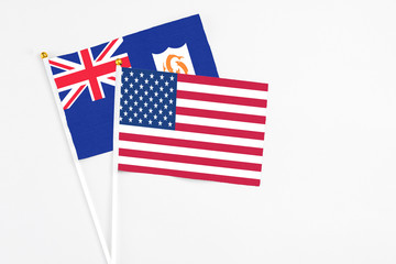 United States and Anguilla stick flags on white background. High quality fabric, miniature national flag. Peaceful global concept.White floor for copy space.