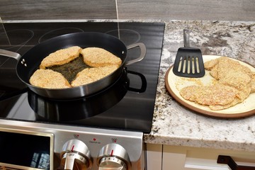 Pan frying breaded chicken fillets for family dinner