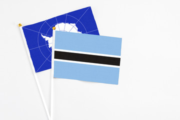 Botswana and Antarctica stick flags on white background. High quality fabric, miniature national flag. Peaceful global concept.White floor for copy space.