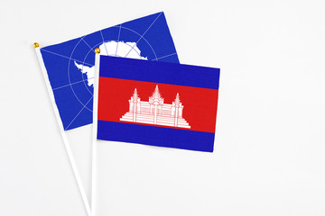 Cambodia and Antarctica stick flags on white background. High quality fabric, miniature national flag. Peaceful global concept.White floor for copy space.