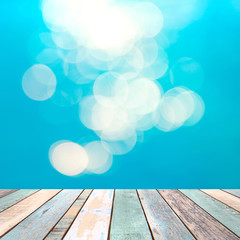 Wood table top and blurry blue water bokeh abstract background