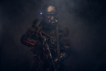 Dark post apocalypse knight is posing for photographer in light smoke.