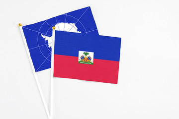 Haiti and Antarctica stick flags on white background. High quality fabric, miniature national flag. Peaceful global concept.White floor for copy space.