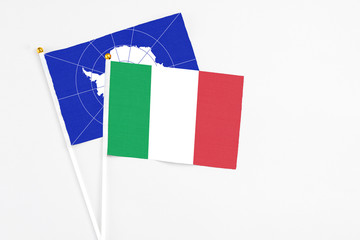 Italy and Antarctica stick flags on white background. High quality fabric, miniature national flag. Peaceful global concept.White floor for copy space.