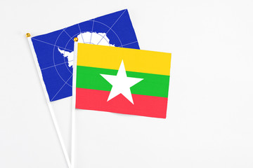 Myanmar and Antarctica stick flags on white background. High quality fabric, miniature national flag. Peaceful global concept.White floor for copy space.