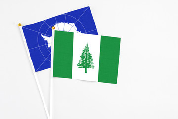 Norfolk Island and Antarctica stick flags on white background. High quality fabric, miniature national flag. Peaceful global concept.White floor for copy space.