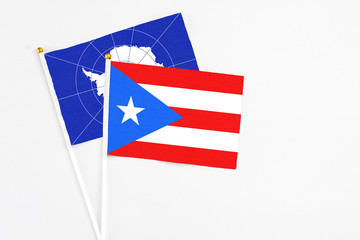 Puerto Rico and Antarctica stick flags on white background. High quality fabric, miniature national flag. Peaceful global concept.White floor for copy space.