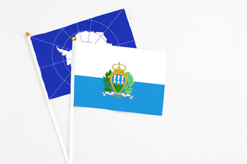 San Marino and Antarctica stick flags on white background. High quality fabric, miniature national flag. Peaceful global concept.White floor for copy space.