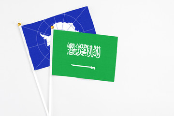 Saudi Arabia and Antarctica stick flags on white background. High quality fabric, miniature national flag. Peaceful global concept.White floor for copy space.