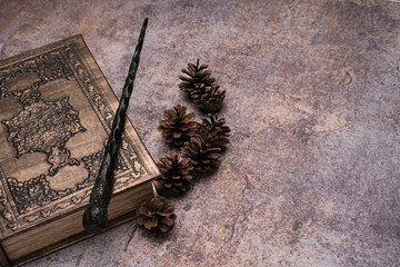Old book with spells and magic wand on gray background. Copy space for text