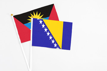 Bosnia Herzegovina and Antigua and Barbuda stick flags on white background. High quality fabric,...