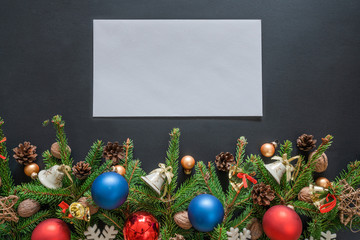 Merry christmas mock up for entering wishes. Green branches on a black background with   decorations. Blank envelope to address.