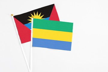 Gabon and Antigua and Barbuda stick flags on white background. High quality fabric, miniature...