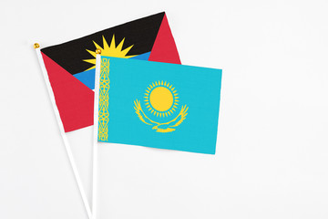 Kazakhstan and Antigua and Barbuda stick flags on white background. High quality fabric, miniature national flag. Peaceful global concept.White floor for copy space.