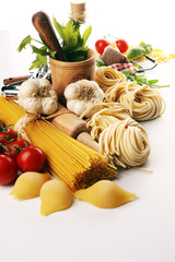 Pasta, vegetables, herbs and spices for Italian food on rustic table
