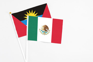 Mexico and Antigua and Barbuda stick flags on white background. High quality fabric, miniature national flag. Peaceful global concept.White floor for copy space.
