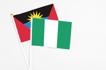 Nigeria and Antigua and Barbuda stick flags on white background. High quality fabric, miniature national flag. Peaceful global concept.White floor for copy space.