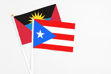 Puerto Rico and Antigua and Barbuda stick flags on white background. High quality fabric, miniature national flag. Peaceful global concept.White floor for copy space.