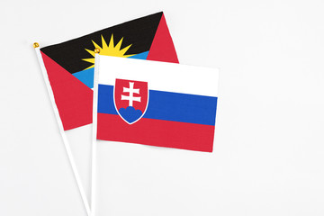 Slovakia and Antigua and Barbuda stick flags on white background. High quality fabric, miniature national flag. Peaceful global concept.White floor for copy space.
