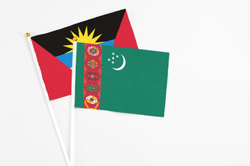 Turkmenistan and Antigua and Barbuda stick flags on white background. High quality fabric, miniature national flag. Peaceful global concept.White floor for copy space.