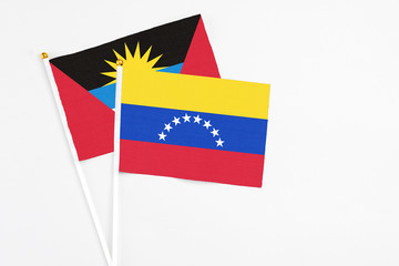 Venezuela and Antigua and Barbuda stick flags on white background. High quality fabric, miniature national flag. Peaceful global concept.White floor for copy space.