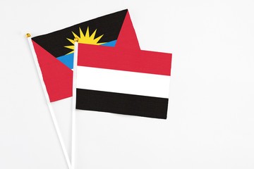 Yemen and Antigua and Barbuda stick flags on white background. High quality fabric, miniature national flag. Peaceful global concept.White floor for copy space.