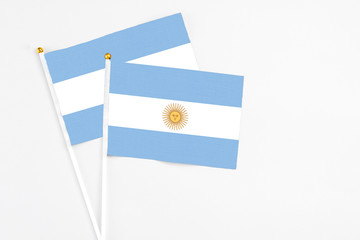 Argentina and Argentina stick flags on white background. High quality fabric, miniature national flag. Peaceful global concept.White floor for copy space.