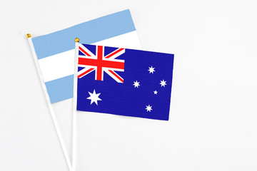 Fototapeta premium Australia and Argentina stick flags on white background. High quality fabric, miniature national flag. Peaceful global concept.White floor for copy space.