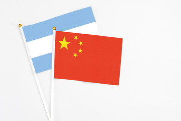 China and Argentina stick flags on white background. High quality fabric, miniature national flag. Peaceful global concept.White floor for copy space.
