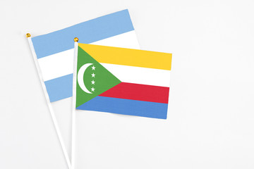 Comoros and Argentina stick flags on white background. High quality fabric, miniature national flag. Peaceful global concept.White floor for copy space.