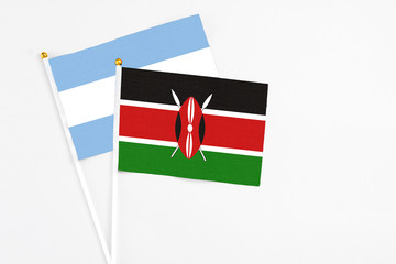 Kenya and Argentina stick flags on white background. High quality fabric, miniature national flag. Peaceful global concept.White floor for copy space.