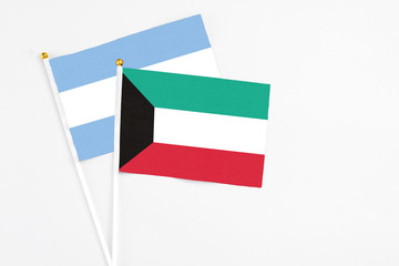 Kuwait and Argentina stick flags on white background. High quality fabric, miniature national flag. Peaceful global concept.White floor for copy space.