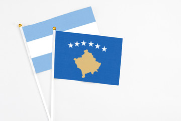 Kosovo and Argentina stick flags on white background. High quality fabric, miniature national flag. Peaceful global concept.White floor for copy space.