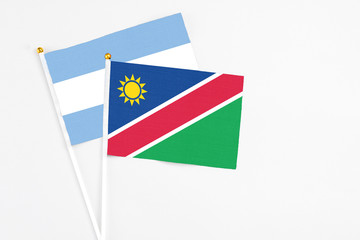 Namibia and Argentina stick flags on white background. High quality fabric, miniature national flag. Peaceful global concept.White floor for copy space.