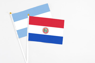 Paraguay and Argentina stick flags on white background. High quality fabric, miniature national flag. Peaceful global concept.White floor for copy space.
