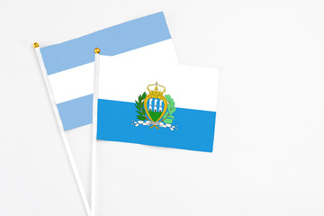 San Marino and Argentina stick flags on white background. High quality fabric, miniature national...