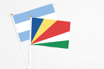 Seychelles and Argentina stick flags on white background. High quality fabric, miniature national flag. Peaceful global concept.White floor for copy space.