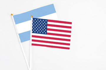 United States and Argentina stick flags on white background. High quality fabric, miniature national flag. Peaceful global concept.White floor for copy space.