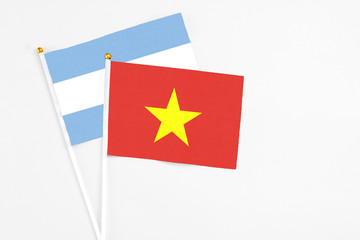 Vietnam and Argentina stick flags on white background. High quality fabric, miniature national flag. Peaceful global concept.White floor for copy space.