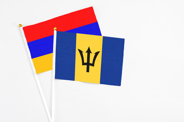 Barbados and Armenia stick flags on white background. High quality fabric, miniature national flag. Peaceful global concept.White floor for copy space.