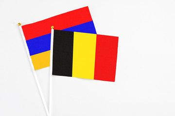 Belgium and Armenia stick flags on white background. High quality fabric, miniature national flag. Peaceful global concept.White floor for copy space.