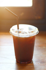 Black coffee with ice on table in cafe.