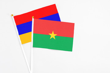 Burkina Faso and Armenia stick flags on white background. High quality fabric, miniature national flag. Peaceful global concept.White floor for copy space.