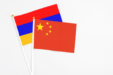 China and Armenia stick flags on white background. High quality fabric, miniature national flag. Peaceful global concept.White floor for copy space.